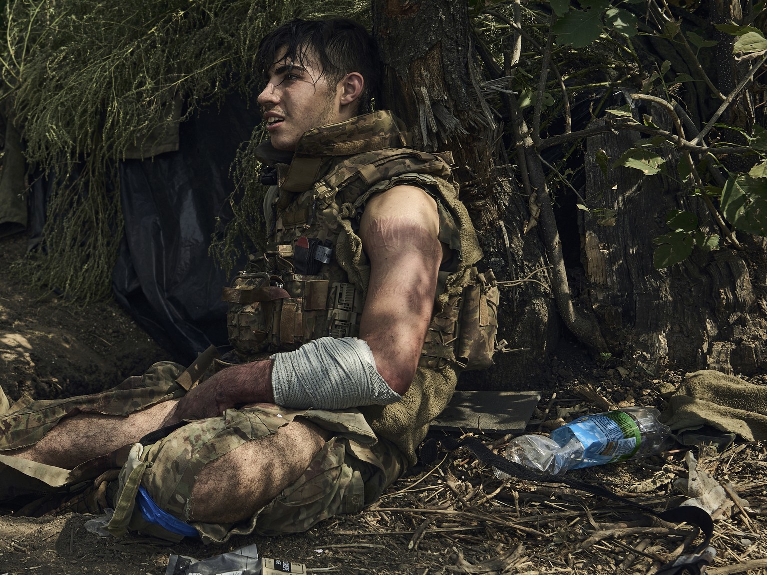 A wounded soldier of Ukraine&#039;s 3rd Separate Assault Brigade, call sign Polumya (Flame), 19, rests after he received first aid as he waits for evacuation near Bakhmut, the site of fierce battles w ...