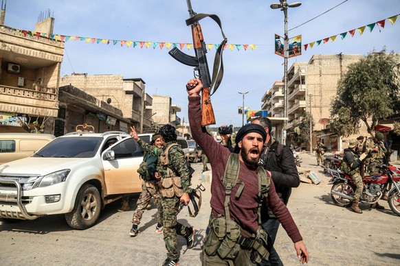 epa06612364 Turkish-backed Free Syrian Army soldiers celebrate after capturing the city of Afrin from Kurdish Popular Protection Units (YPG) forces, northern Syria, 18 March 2018. Turkish President Re ...