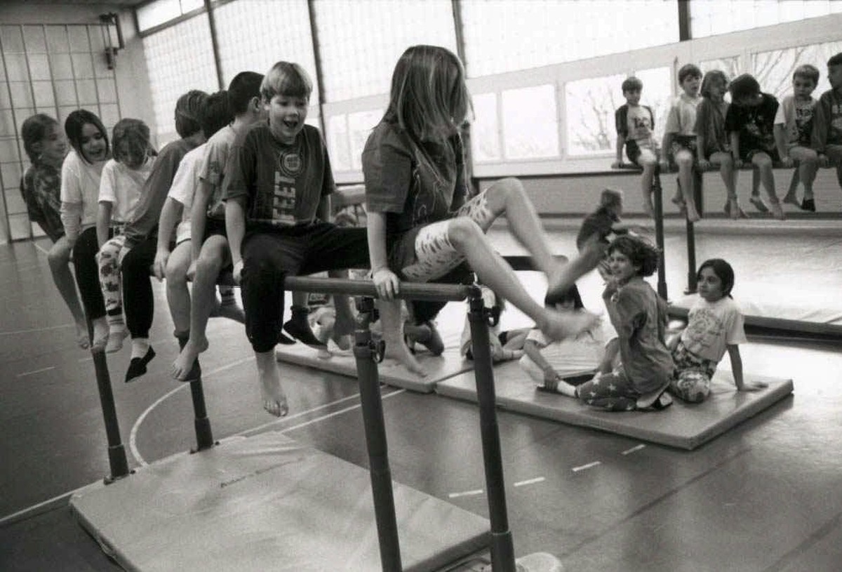 Turnen in der Schule, Schueler und Schuelerinnen am Barren beim Turnen im Schulunterricht, Turnhalle. (KEYSTONE/Martin Ruetschi) === ===