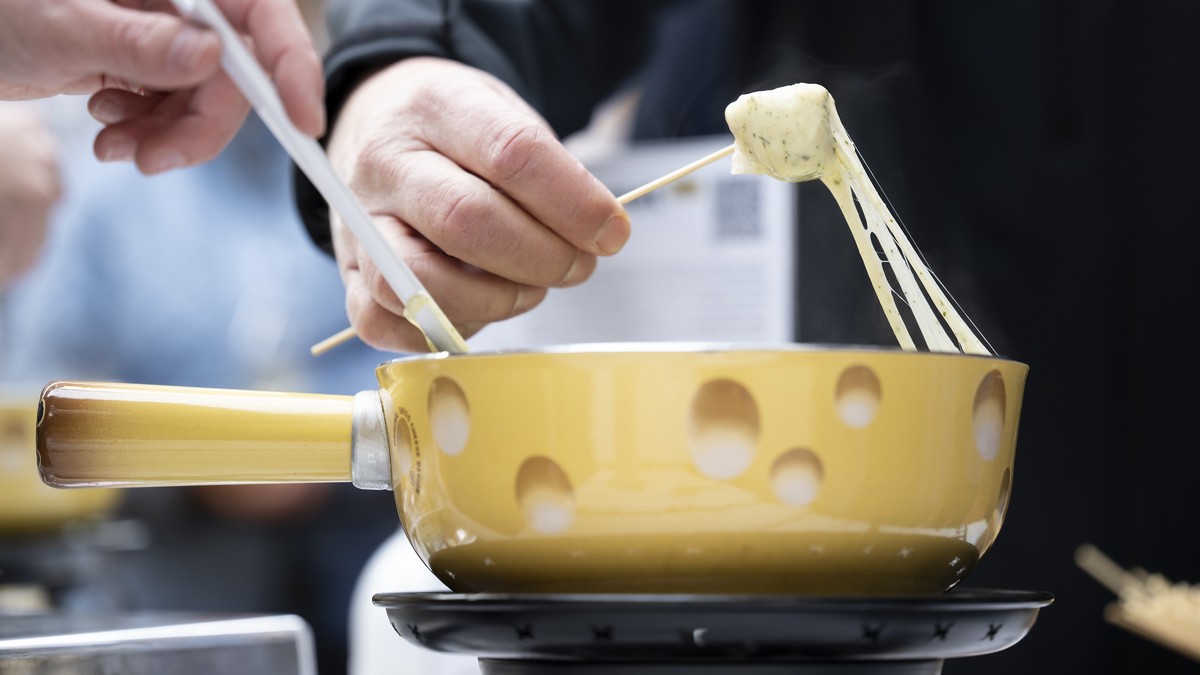 Un visiteur goute une fondue lors du 1er Suisse fondue festival, ce jeudi 17 novembre 2022, sur la place Georges-Python, a Fribourg. Cette premier edition qui se deroule du 17 au 20 novembre, met la f ...