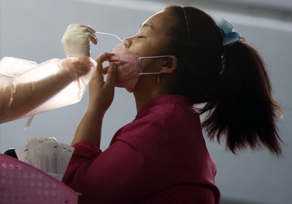 epa09678166 A Thai woman has her swab sample collected during a COVID-19 antigen test at a newly set up testing center to curb the surge of coronavirus infections in Bangkok, Thailand, 11 January 2022 ...