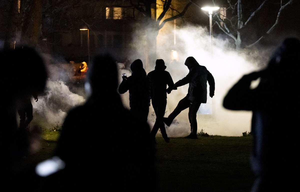 epa09895563 A tear gas torch is kicked away on Ramel's road during a protest at Rosengard in Malmo, Sweden, 18 April 2022. The police went to the scene with a large number of vehicles and fired t ...