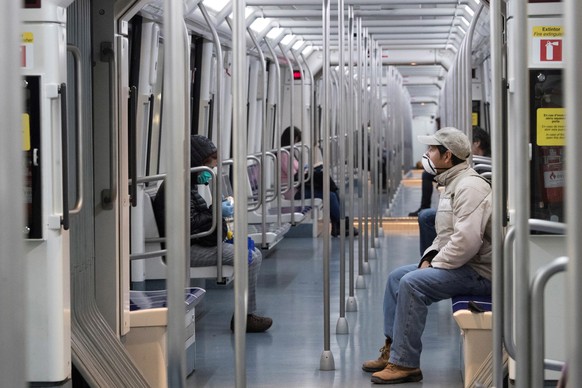 epa08314915 Commuters wearing protective face masks on board a subway train in Barcelona, northeastern Spain, 23 March 2020. Spain is on a ninth day of a national lockdown aimed to slow down the sprea ...