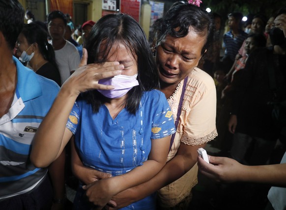 epa09530198 A released woman (L) reacts as she meets with her mother outside the Insein prison in Yangon, Myanmar, 18 October 2021. Myanmar's junta chief Min Aung Haling announced the released of over ...