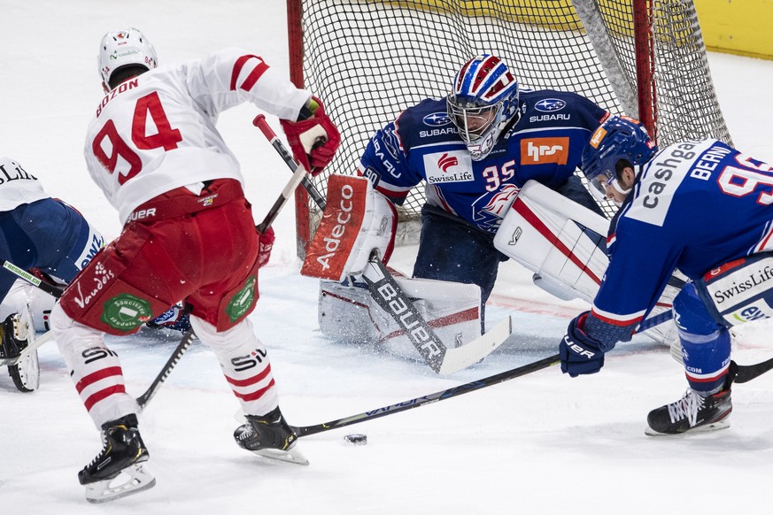 Lausannes Tim Bozon, links, kaempft um den Puck gegen Zuerichs Torhueter Ludovic Waeber, rechts, im sechsten Eishockey Playoff-Viertelfinalspiel der National League zwischen den ZSC Lions und dem Laus ...