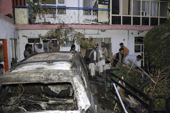 FILE - In this Sunday, Aug. 29, 2021 file photo, Afghans inspect damage of Ahmadi family house after U.S. drone strike in Kabul, Afghanistan. The Pentagon retreated from its defense of a drone strike  ...