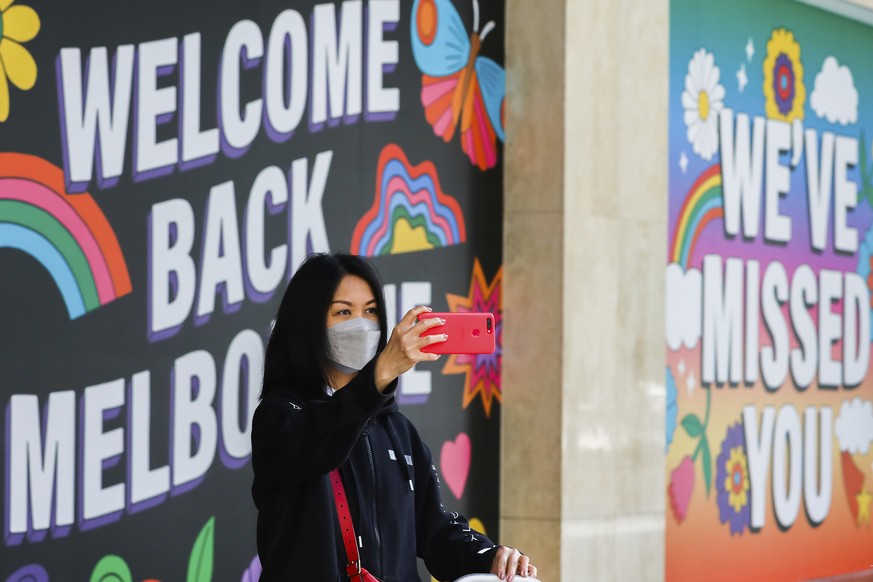 A woman takes a selfie in front of signage in Melbourne, Australia, Wednesday, Oct. 28, 2020. Australia���s second largest city of Melbourne which was a coronavirus hotspot emerges from a nearly four- ...