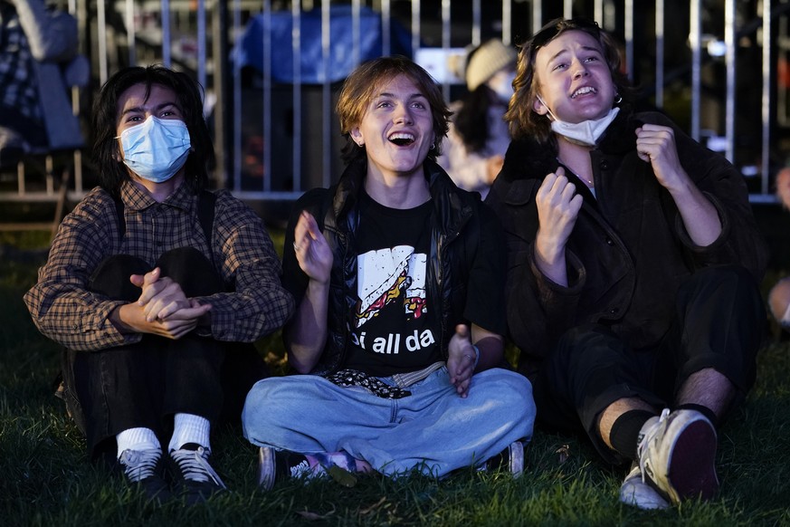 From left, Niki Gotzev, Milo Shea and Ryan Thomas, all of the District of Columbia, react to local election results, Tuesday, Nov. 3, 2020, in Washington. (AP Photo/Jacquelyn Martin)