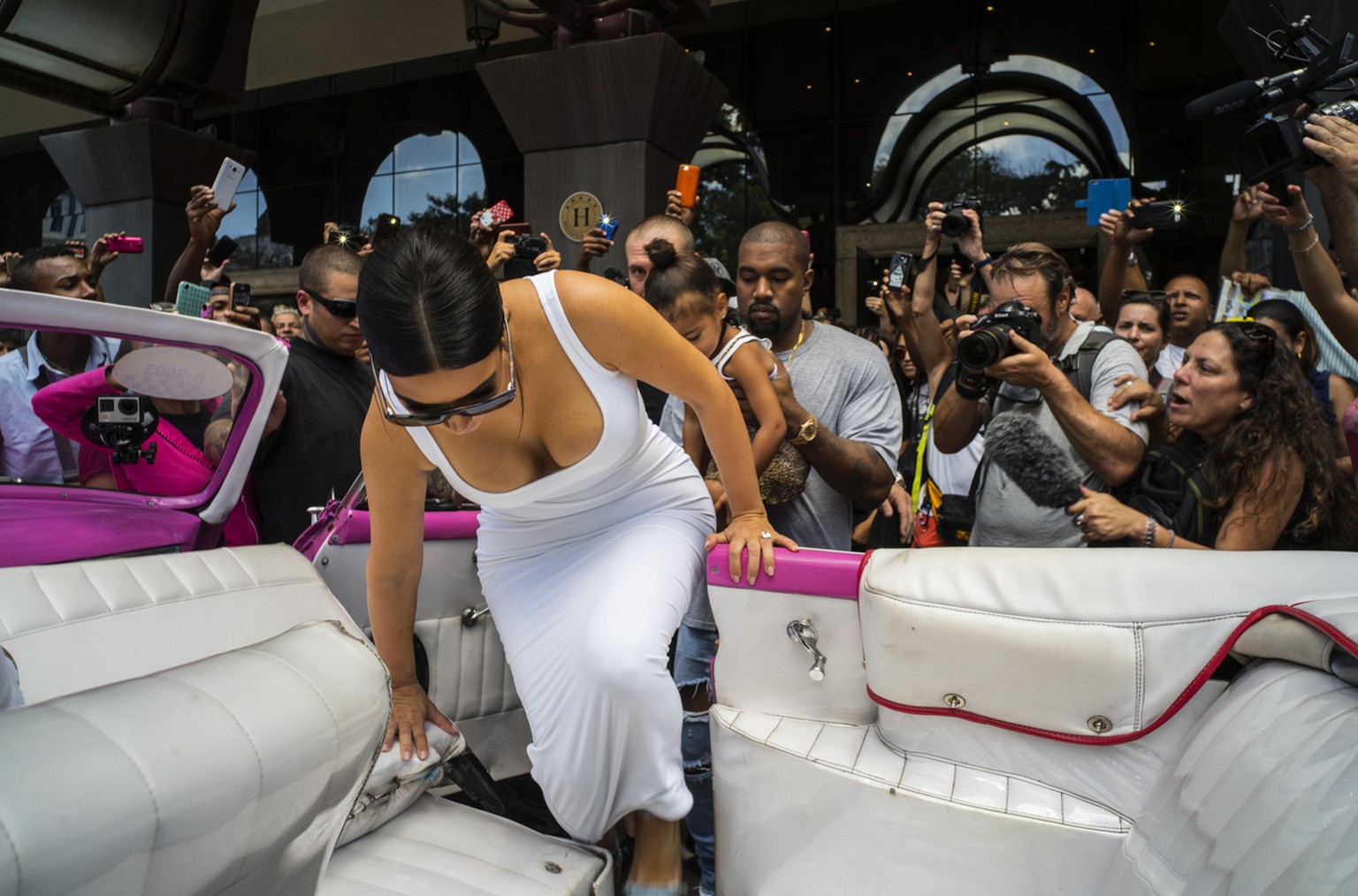 American reality-show star Kim Kardashian gets into a classic car, followed by her husband, rap singer Kanye West and their daughter North West in Havana, Cuba, Thursday, May 5, 2016. West, Kardashian ...