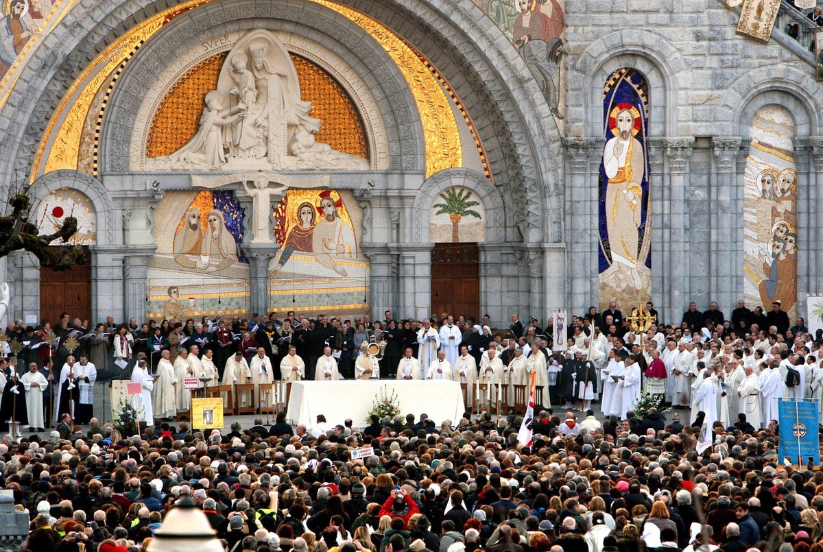 Priests and pilgrims attend an eucharistic procession in front of Notre-Dame Cathedral in Lourdes, France, Monday, Feb. 11, 2008. Catholic pilgrims on Monday mark the 150th anniversary of the appariti ...