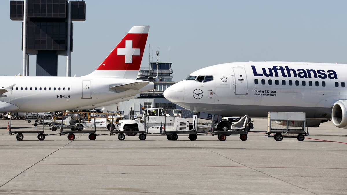 An aircraft (Boeing 737-300 D-ABEN) of the Lufthansa is push back next to an aircraft (Airbus A320 HB-IJH) of the Swiss International Air Lines at the Geneva Airport, in Geneva, Switzerland, Wednesday ...