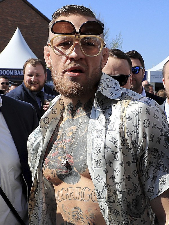 Irish boxer Conor McGregor, right, arrives on Grand National Day of the Grand National Festival at Aintree Racecourse in Liverpool, England, Saturday, April 8, 2017. (Peter Byrne/PA via AP)