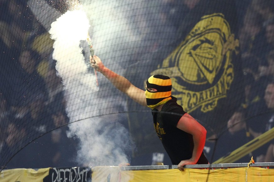 Ein YB Fan zuendet Pyro an beim Fussball Meisterschaftsspiel der Super League zwischen dem BSC Young Boys und dem FC Zuerich am Dienstag, 1. Mai 2012, im Stade de Suisse Wankdorf in Bern. (KEYSTONE/Pe ...