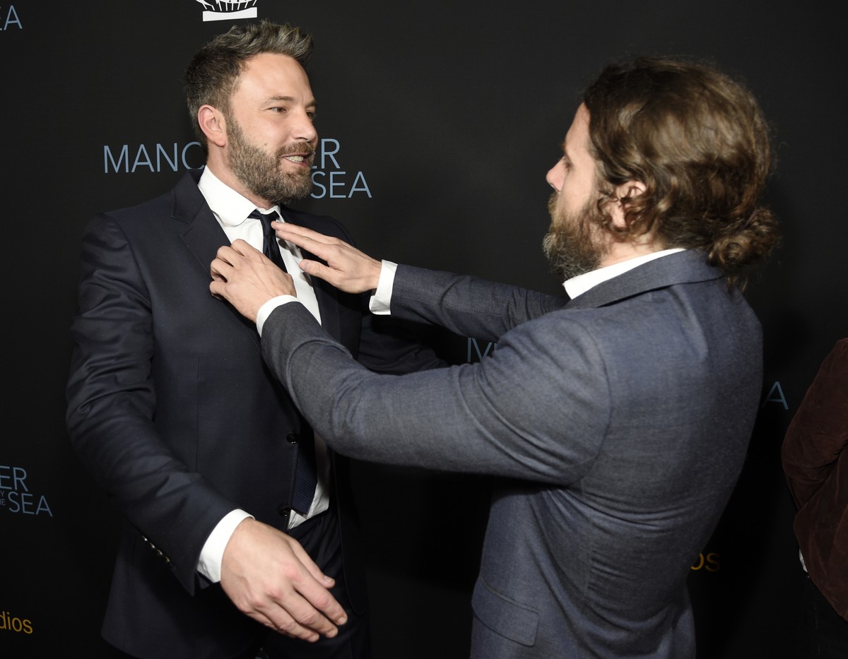 Casey Affleck, right, a cast member in "Manchester by the Sea," fixes the tie of his brother Ben Affleck at the premiere of the film at the Samuel Goldwyn Theater on Monday, Nov. 14, 2016, i ...