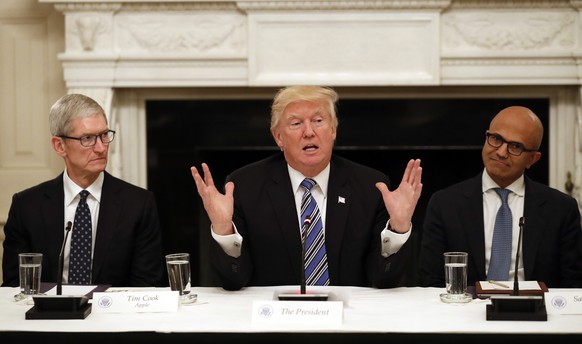 President Donald Trump, center, speaks as he is seated between Tim Cook, Chief Executive Officer of Apple, left, and Satya Nadella, Chief Executive Officer of Microsoft, right, during an American Tech ...