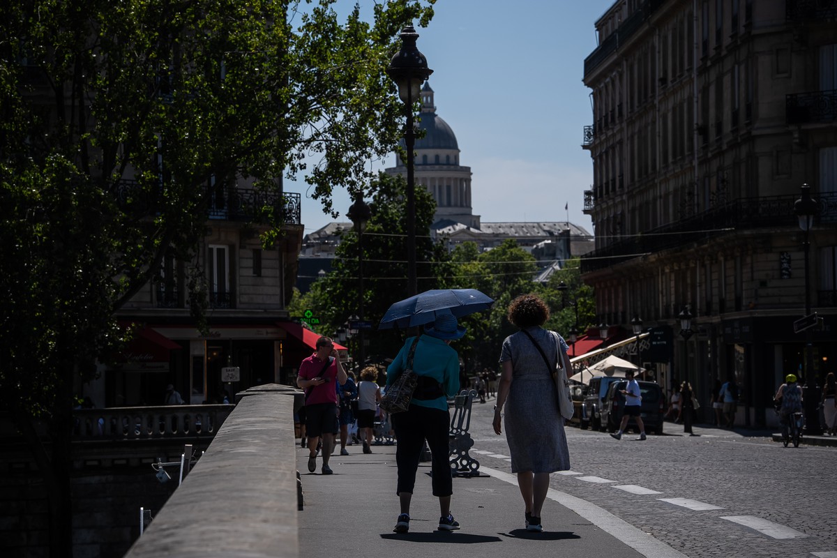 A woman walks with a umbrella in Paris during a heat wave, Saturday, July 11, 2026. (AP Photo/Aurelien Morissard)
France Extreme Weather Heat