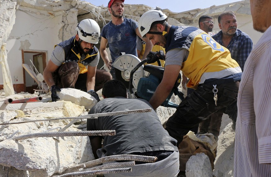 This photo provided by the Syrian Civil Defense White Helmets, which has been authenticated based on its contents and other AP reporting, shows Civil Defense workers searching for victims under the ru ...