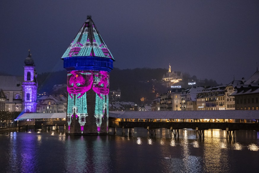 Die Lichtprojektion �Reuss&quot; von der Kuenstlerin Kasia Pawlosky am Wasserturm der Kapellbruecke anlaesslich dem Pre-Opening des Lilu Lichtfestival Luzern vom Mittwoch, 10. Januar 2024 in Luzern. A ...