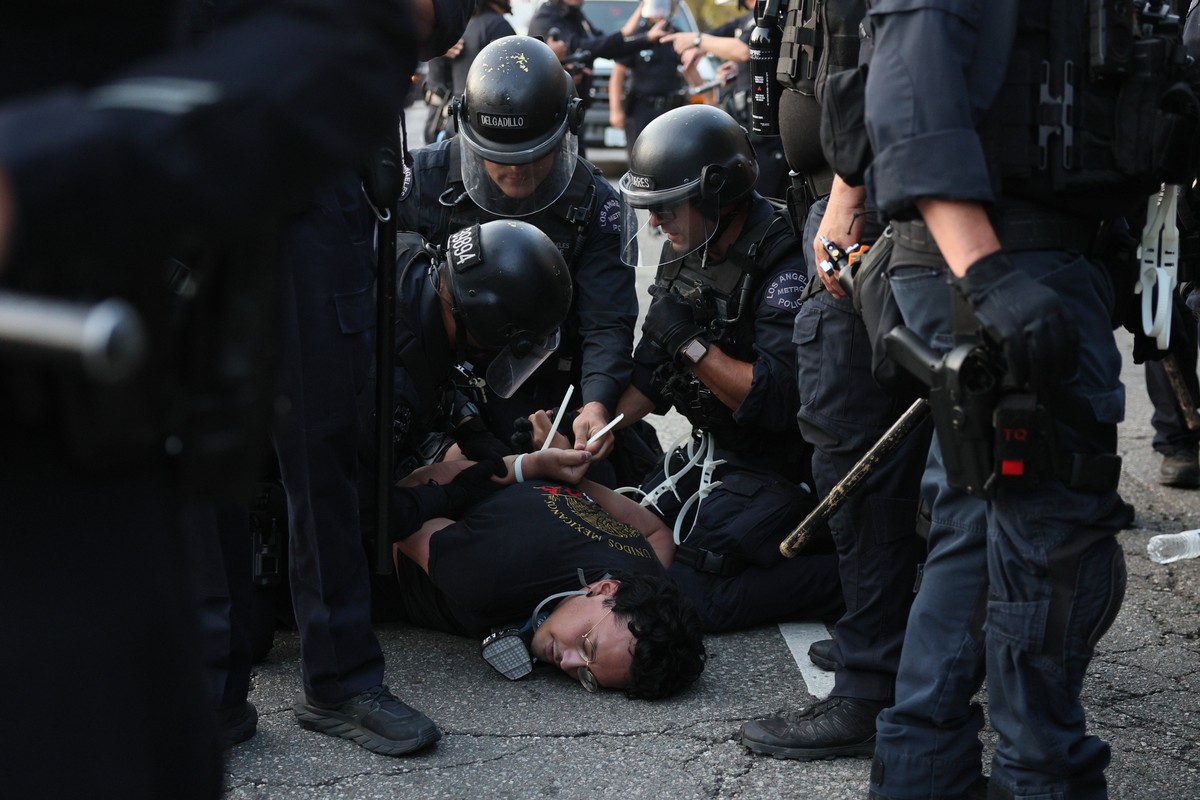 epaselect epa12167302 Police detain a protester as they clash in Los Angeles, California, USA, 09 June 2025. Approximately 2,000 National Guard troops were deployed on 08 June in Los Angeles by US Pre ...