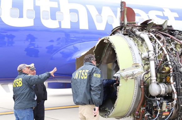 epa06675912 A handout photo made available by the National Transportation Safety Board shows investigators examining the damaged engine of Southwest Airlines flight 1380 which was en route from LaGuar ...