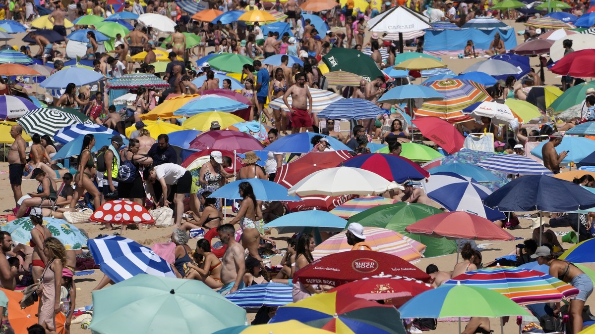 People crowd the Carcavelos beach, outside Lisbon, Friday, July 8, 2022. Portugal's government on Friday declared an eight-day state of alert due to the heightened risk of wildfires, as the droug ...