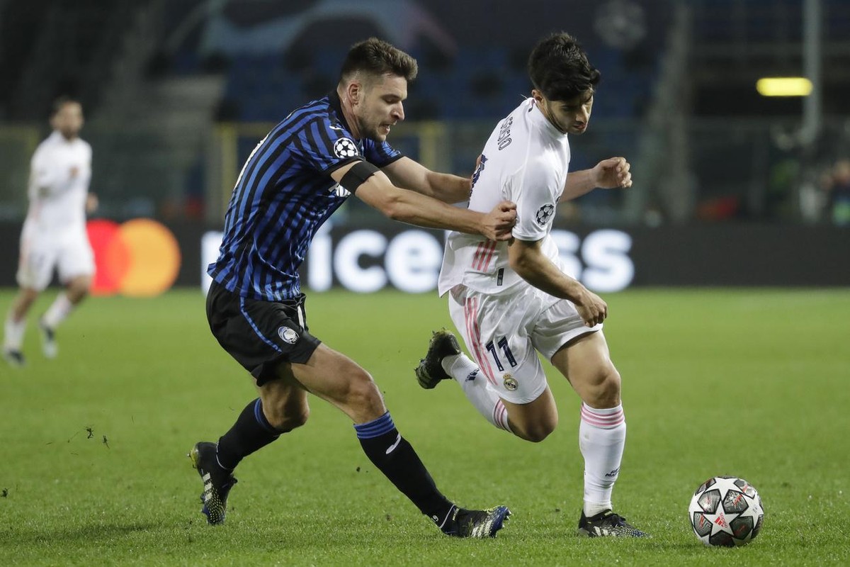 Real Madrid's Marco Asensio, right, is challenged by Atalanta's Berat Djimsiti during the Champions League, round of 16, first leg soccer match between Atlanta and Real Madrid, at the Gewiss ...