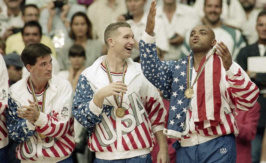 FILE - In this Aug. 8, 1992, file photo, From left the USA's John Stockton, Chris Mullin, and Charles Barkley rejoice with their gold medals after beating Croatia 117-85 in the gold medal game in men' ...