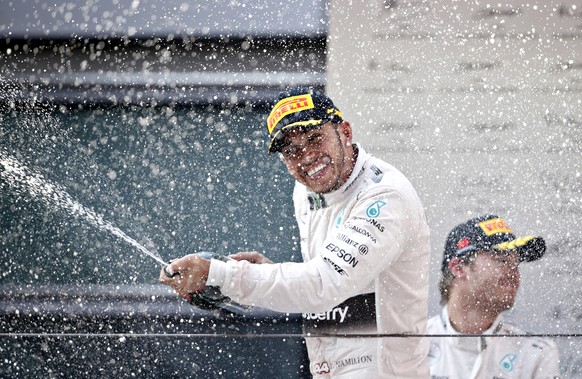 Mercedes Formula One driver Lewis Hamilton of Britain sprays champagne as he celebrates his victory on the podium after the Chinese F1 Grand Prix at the Shanghai International Circuit, April 12, 2015. REUTERS/Aly Song      TPX IMAGES OF THE DAY     