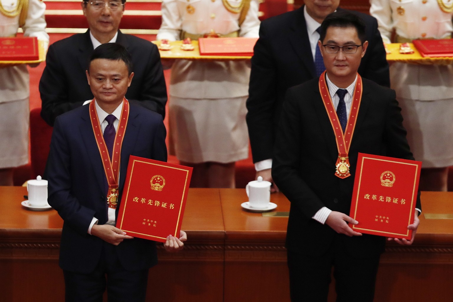 epa07237978 Tencent&#039;s Chief Executive Officer Pony Ma (also known as Ma Huateng, R) and Alibaba&#039;s Executive Chairman Jack Ma (L) hold certificates during a meeting held to celebrate the 40th ...