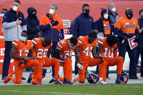 Members of the Denver Broncos take a knee during the national anthem before an NFL football game against the Buffalo Bills, Saturday, Dec. 19, 2020, in Denver. (AP Photo/David Zalubowski)