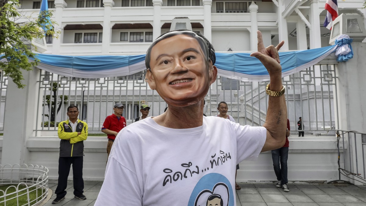 epa10812973 A supporters of former Thai prime minister Thaksin Shinawatra wears a mask depicting Shinawatra, outside the Supreme Court in Bangkok, Thailand, 22 August 2023. Shinawatra returned to Thai ...