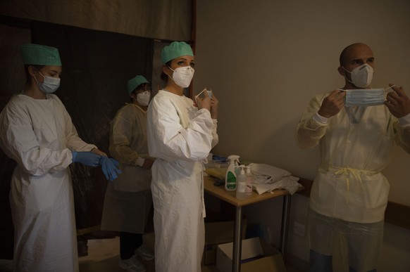 Belgian Army healthcare workers and supervisory personnel suit up prior to doing their rounds in the COVID-19 ward of the CHC nursing home in Landenne, Belgium, Wednesday, Nov. 4, 2020. Belgium, propo ...