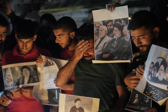 A Shiite Muslim weeps as they hold photos of Iranian President Ebrahim Raisi and others leaders during a vigil in Srinagar, Indian controlled Kashmir, Monday, May 20, 2024. Raisi and several other off ...