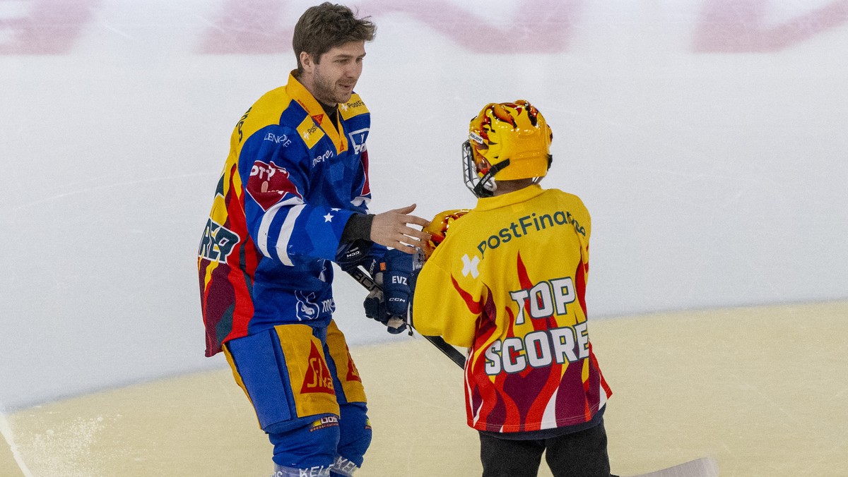 PostFinance Top Scorer Lino Martschini, links, von Zug mit einem Einlauf Kidd beim Eishockey Qualifikationsspiel der National League zwischen dem EV Zug und den Lausanne HC am Samstag, 1. Maerz 2025 i ...