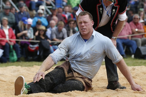 Matthias Sempach liegt nach dem fuenften Gang gegen Reto Schmid verletzt im Saegemehl, beim Oberaargauischen Schwingfest, am Samstag, 23. Mai 2015 in Seeberg-Grasswil. (KEYSTONE/Peter Klaunzer)