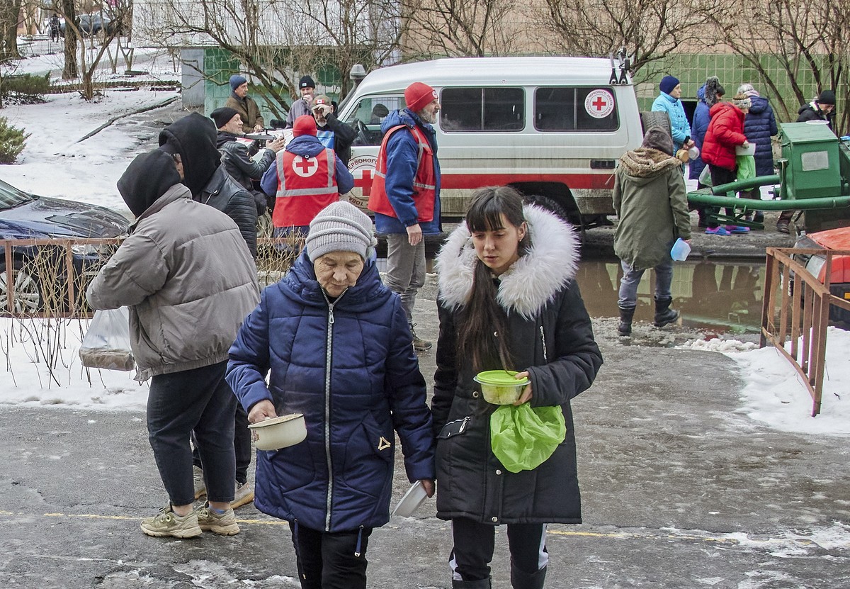 epa10466895 Ukrainian internally displaced people receive hot food from volounteers at a street of Kharkiv, Eastern Ukraine, 14 February 2023. On Valentine's Day, Red Cross volunteers in coordina ...
