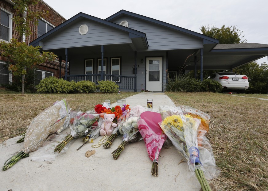 Flowers lie on the sidewalk in front of the house in Fort Worth, Texas, Monday, Oct. 14, 2019. A white Fort Worth police officer who shot and killed a black woman through a back window of her home whi ...