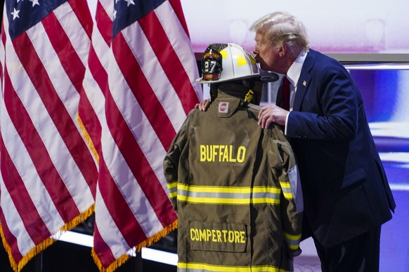 epa11486666 Republican presidential nominee and former President Donald J. Trump kisses the uniform of Cory Compertore, the retired firefighter killed in the assassination attempt, delivers remarks du ...