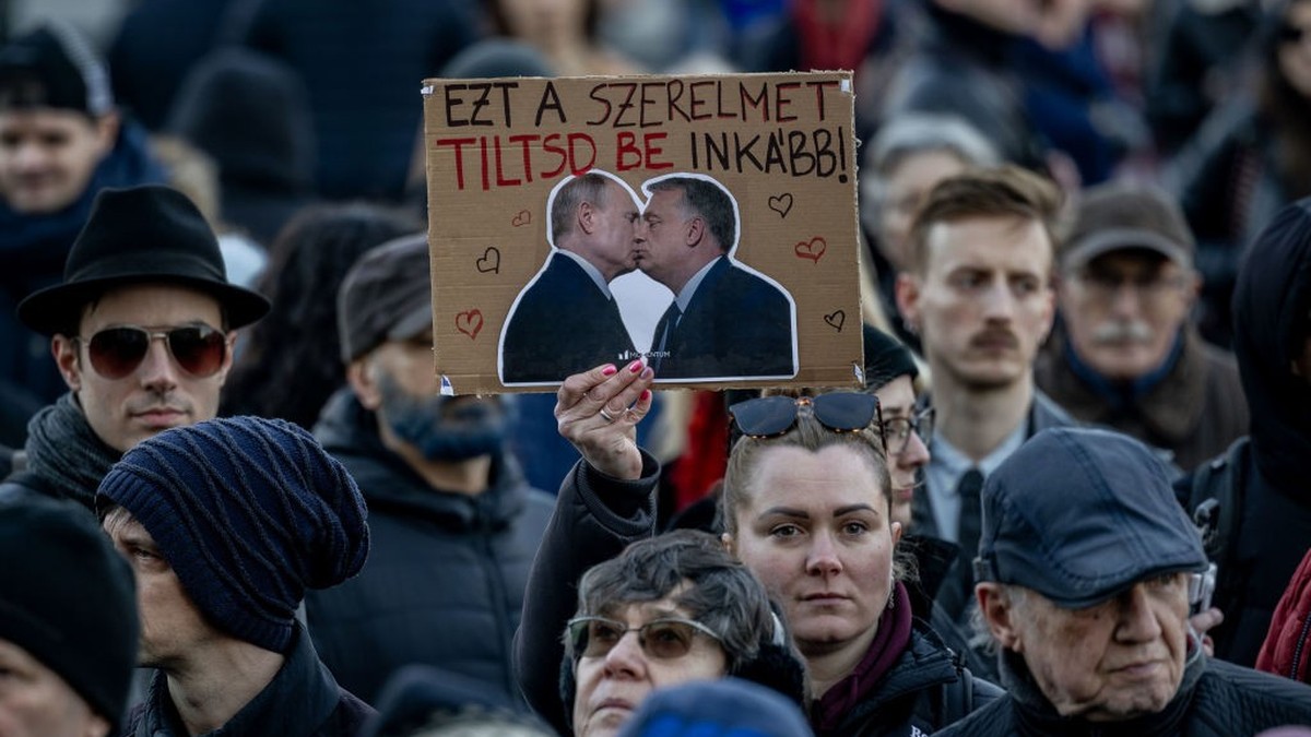 BUDAPEST, HUNGARY - MARCH 18: A demonstrator holds a banner that shows Vladimir Putin and Viktor Orban kissing during a protest on March 18, 2025 in Budapest, Hungary. A new bill proposed by the rulin ...