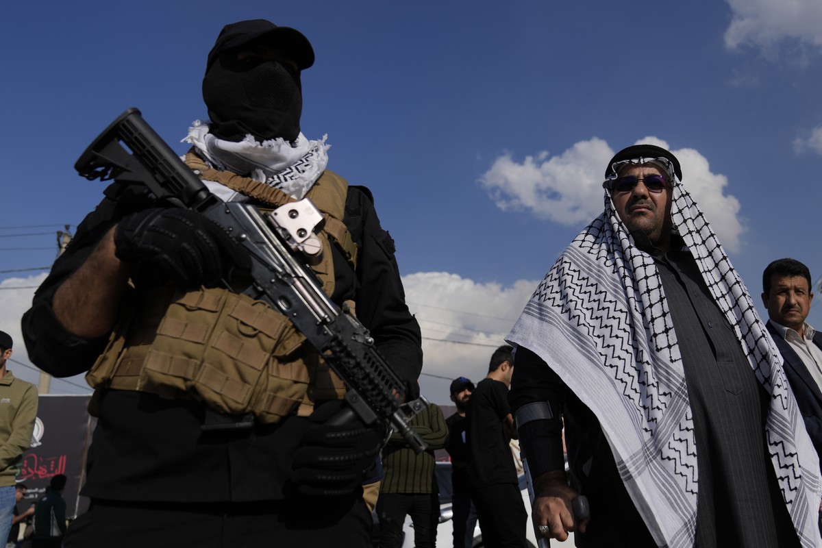 Members of an Iraqi Shiite militant group attend the funeral of a fighter with the Kataib Hezbollah, who was killed in a U.S. airstrike, in Baghdad, Iraq, Thursday, Jan. 25, 2024. (AP Photo/Hadi Mizba ...