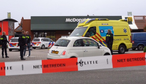 epa09861364 Policemen guard the scene outside a branch of McDonald&#039;s fast food chain in Zwolle-Noord, The Netherlands, where two local men were shot, 30 March 2022 (issued 31 March 2022). No arre ...