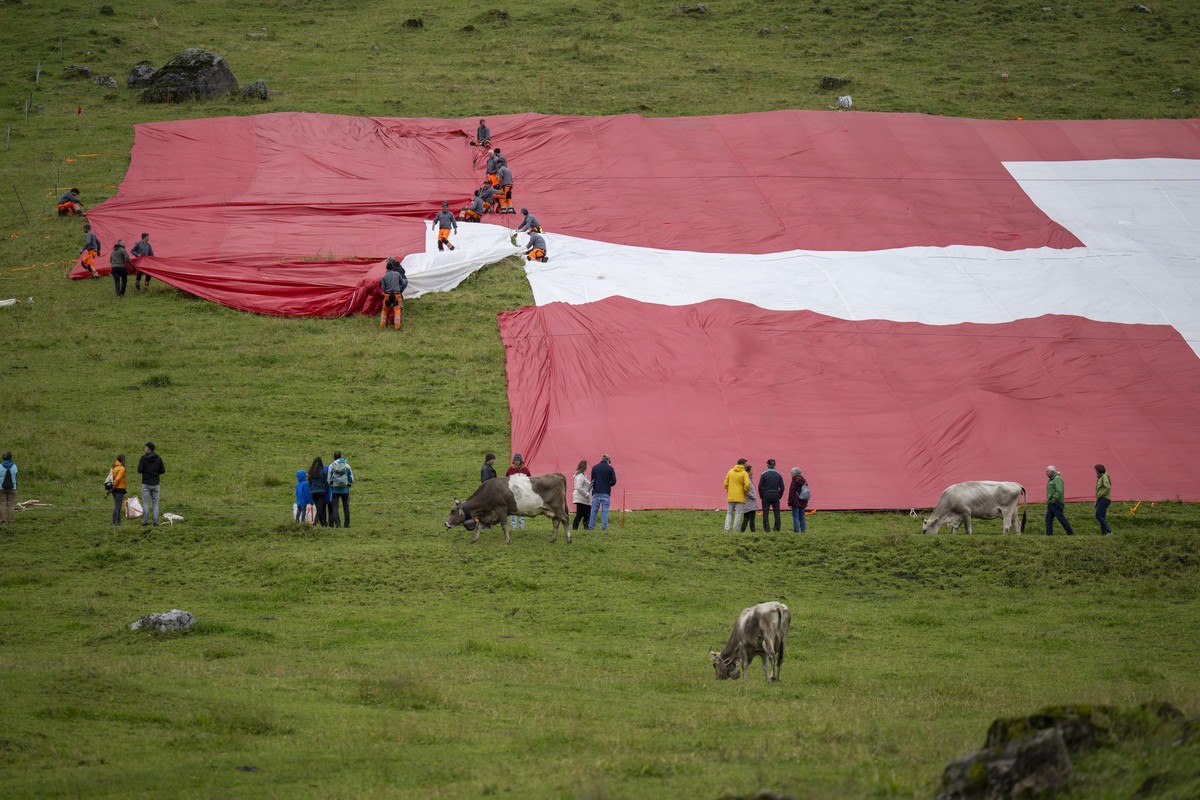 Arbeiter flicken die groesste Schweizerfahne der Schweiz, nachdem diese kurz nach dem Auslegen zerrissen ist, anlaesslich des Nationalfeiertags, am Donnerstag, 31. Juli 2025, auf der Schwaegalp. Wegen ...
