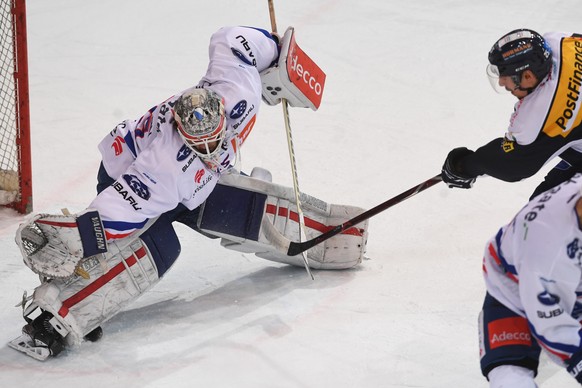 Zurich&#039;s goalkeeper Daniel Guntern, left, during the 2-2 score of Ambri&#039;s player Mattia Hinterkircher, right, during the preliminary round game of National League A (NLA) Swiss Championship  ...