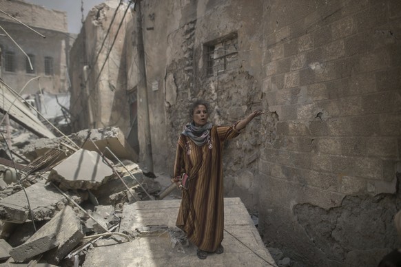 A civilian flees through a destroyed alley as Iraqi Special Forces continue their advance against Islamic State militants, in the Old City of Mosul, Iraq, Sunday, July 2, 2017. (AP Photo/Felipe Dana)