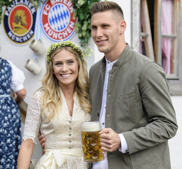 Niklas Suele, right, player of the German first division, Bundeliga, soccer team FC Bayern Munich, and his girlfriend Melissa Halter, left, arrive at the &#039;Oktoberfest&#039; beer festival in Munic ...