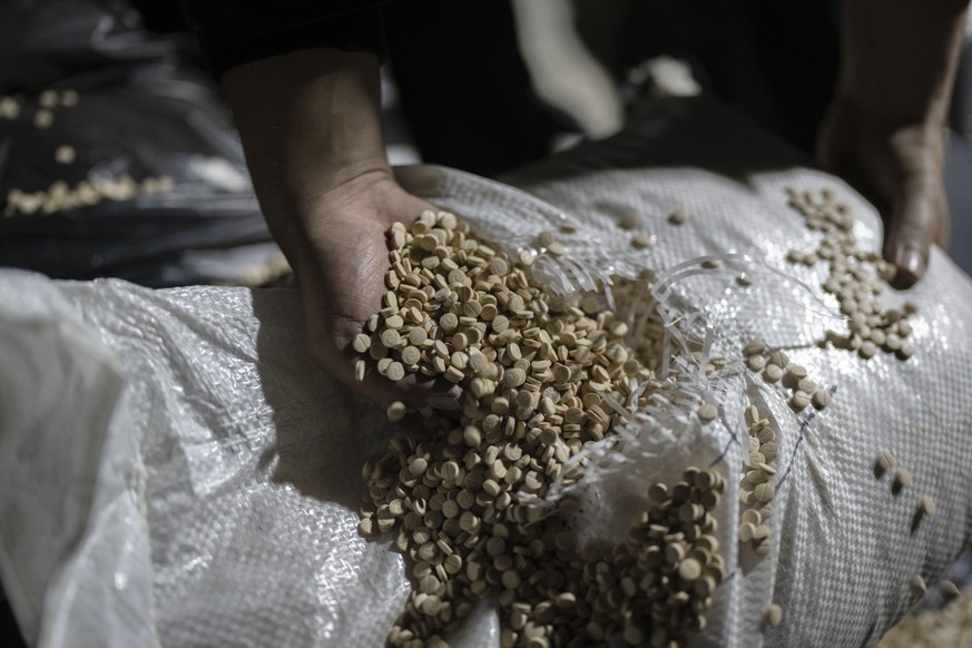 Members of the Syrian security forces inspect amphetamine pills, known as Captagon, inside a military headquarters where it was manufactured before the fall of Bashar Assad government outskirts of Dam ...