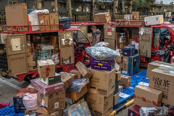epa09575425 An employee for Chinese e-commerce giant JD.com stands next to packages for delivery on Singles&#039; Day or &#039;11.11&#039; Global Shopping Festival, in Beijing, China, 11 November 2021 ...