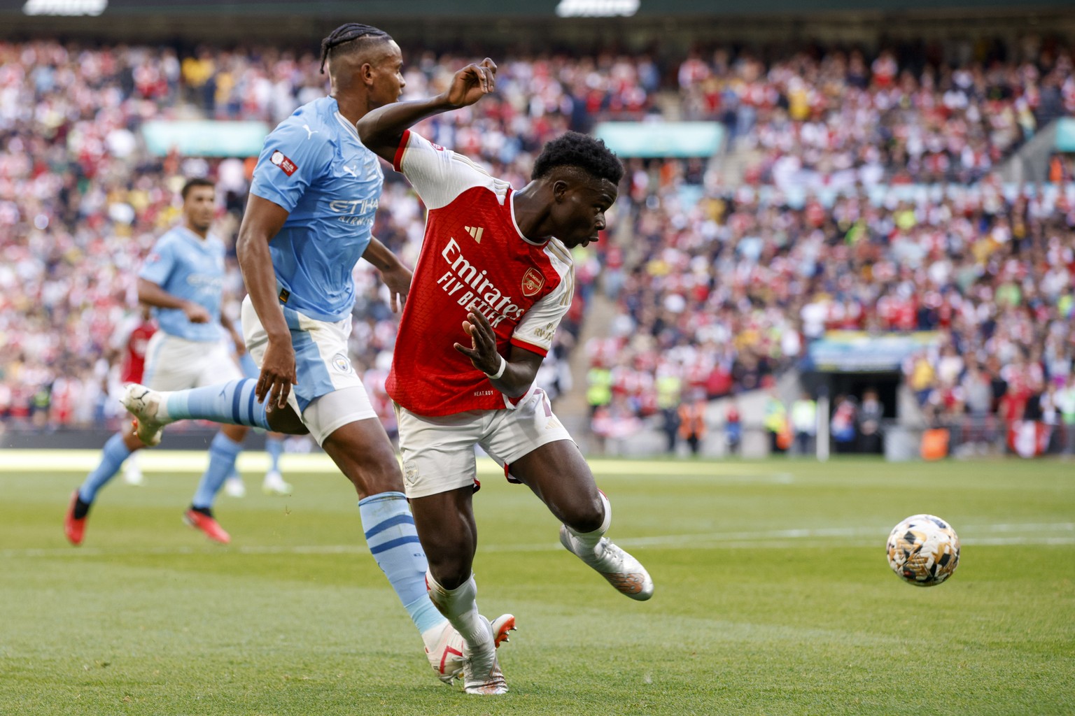 Arsenal&#039;s Bukayo Saka, front, duels for the ball with Manchester City&#039;s Manuel Akanji during the English FA Community Shield final soccer match between Arsenal and Manchester City at Wembley ...