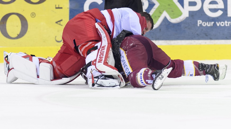 Le gardien lausannois, Cristobal Huet, droite, a la lutte avec le joueur genevois, Nathan Gerbe, gauche, lors du match du championnat suisse de hockey sur glace de National League, entre le Geneve Ser ...