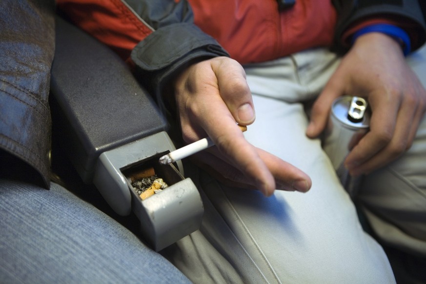 A man smokes a cigarette in a smoking compartment of a train from Zurich to Winterthur, Switzerland, on November 9, 2005. (KEYSTONE/Martin Ruetschi) 

Ein Passagier raucht im Raucherabteil der SBB zwi ...